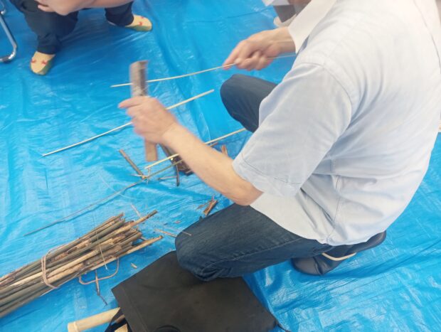 男性がたけひごを作成している